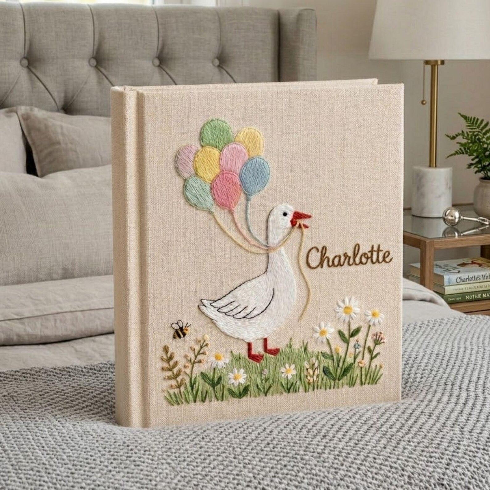 Personalized goose hand embroidered baby photo album with pastel balloons and floral meadow design on linen cover