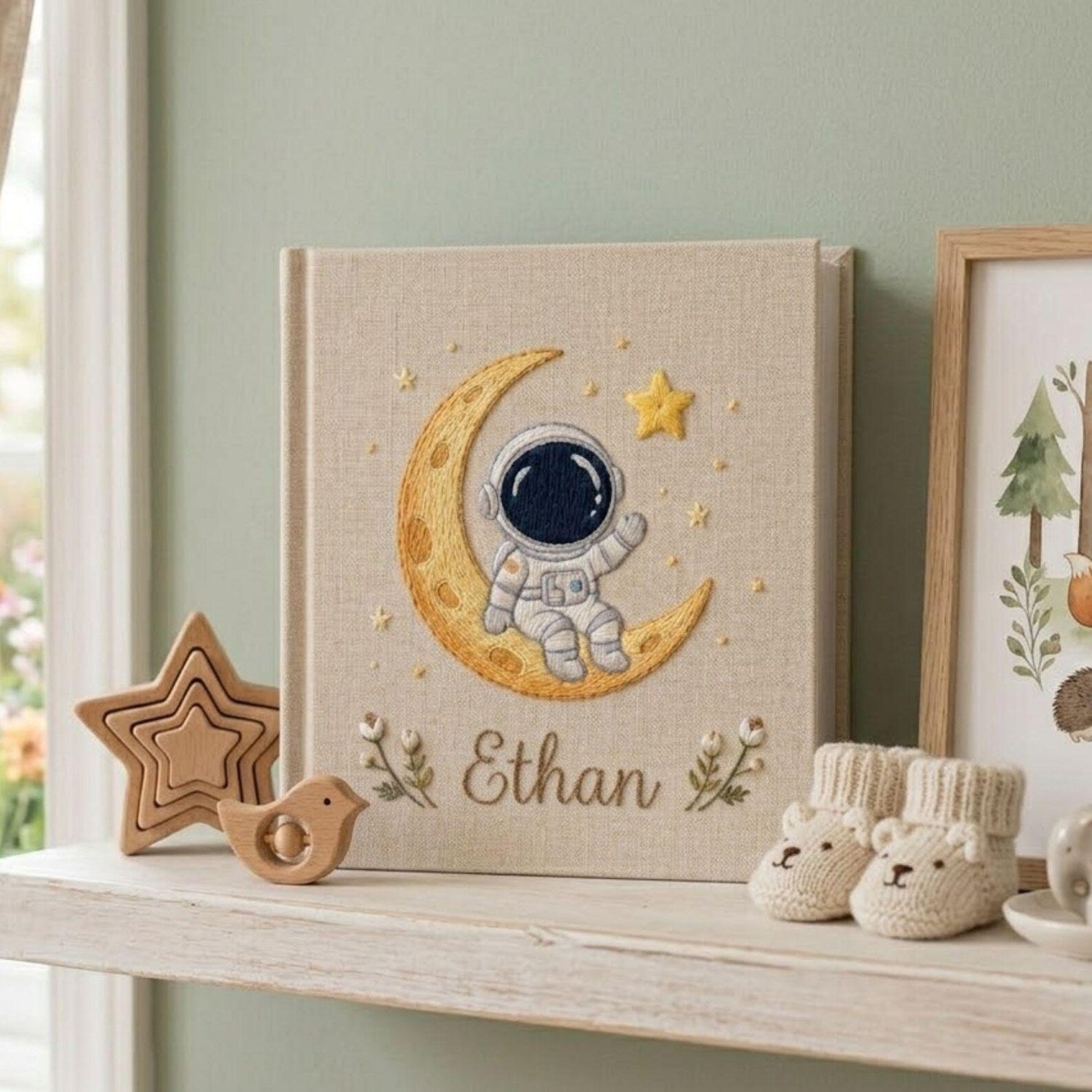 Personalized hand embroidered baby photo album with astronaut sitting on crescent moon and stars nursery design