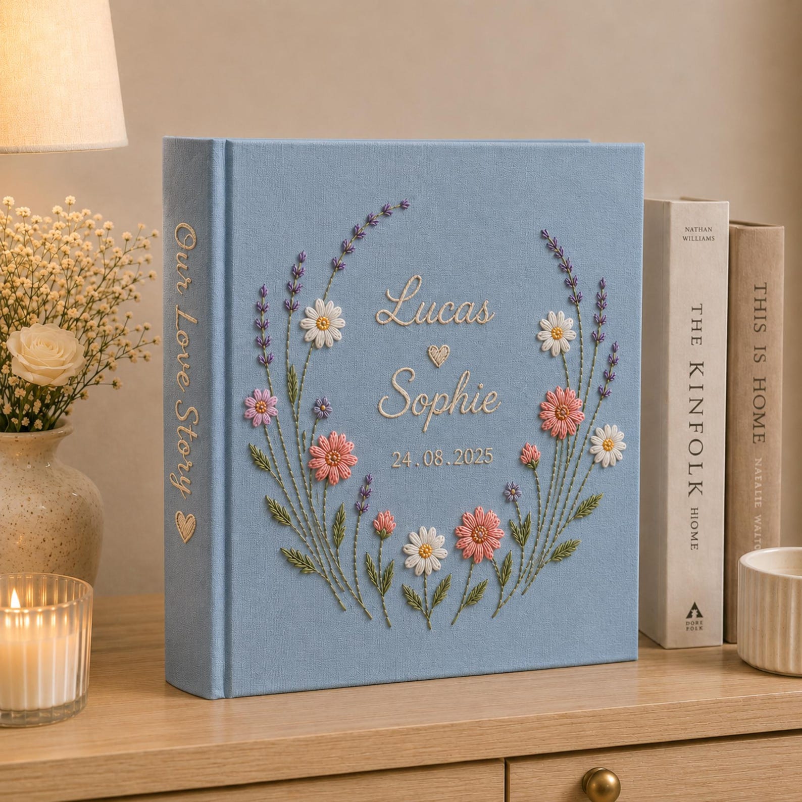 Personalized hand embroidered wedding photo album with floral wreath design, custom names and wedding date on blue linen cover