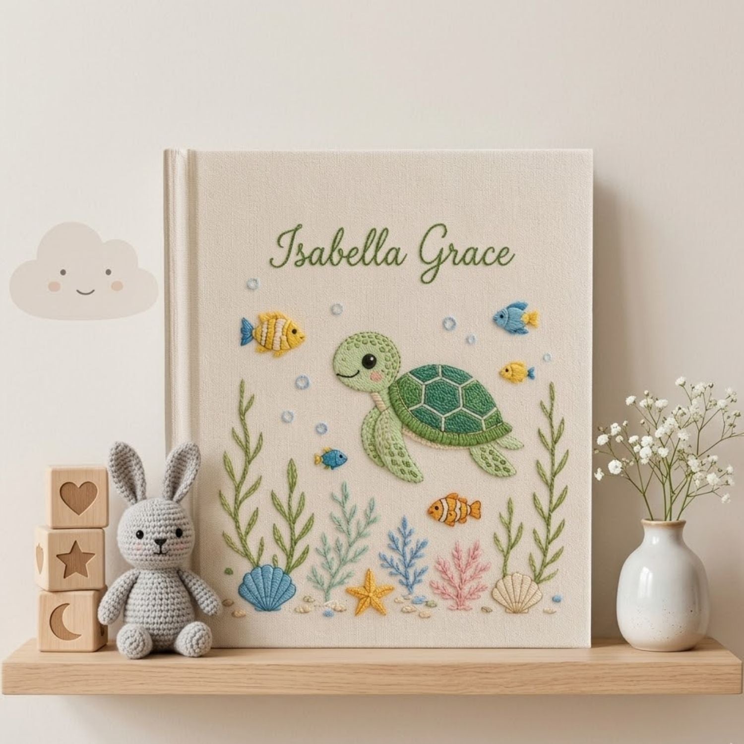 Personalized hand embroidered photo album featuring a cute sea turtle swimming with tropical fish, coral, seashells, and ocean plants on a premium linen cover customized with a baby name