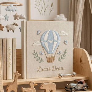 Personalized hand embroidered photo album featuring a blue hot air balloon with butterflies clouds and custom baby name