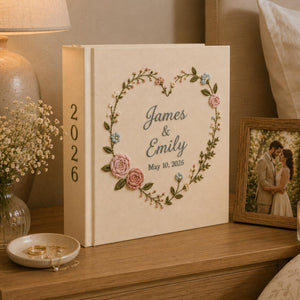 Personalized embroidered wedding photo album with floral heart wreath, pastel flower embroidery, custom names, wedding date, and linen hardcover design