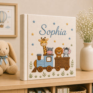 Personalized hand embroidered photo album featuring a safari animal train with giraffe, hippo, lion and zebra on a linen cover