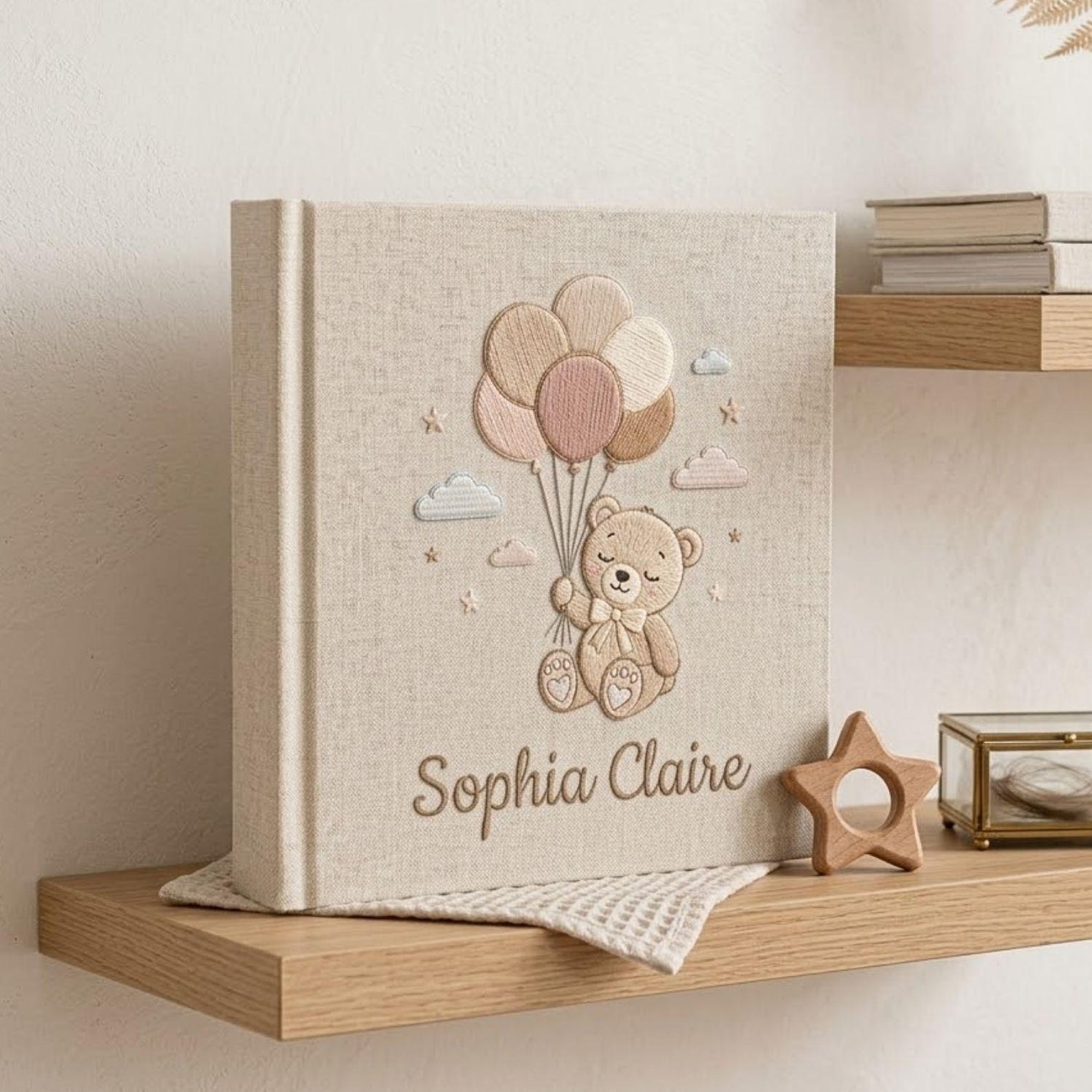 Personalized hand embroidered photo album featuring a teddy bear holding pastel balloons with custom embroidered baby name