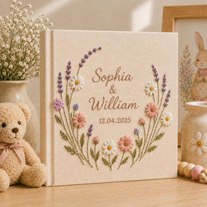 Custom botanical embroidered wedding photo albums with lavender flowers, butterflies, ribbon bows, and personalized couple names on linen covers