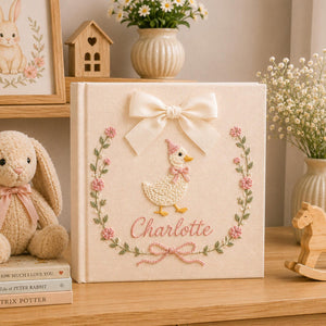 Personalized pink hand embroidered baby photo album with duckling, floral wreath, and ribbon bow