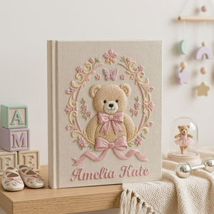 Personalized hand embroidered photo album featuring a vintage teddy bear surrounded by a floral wreath, pink bows and delicate butterfly accents