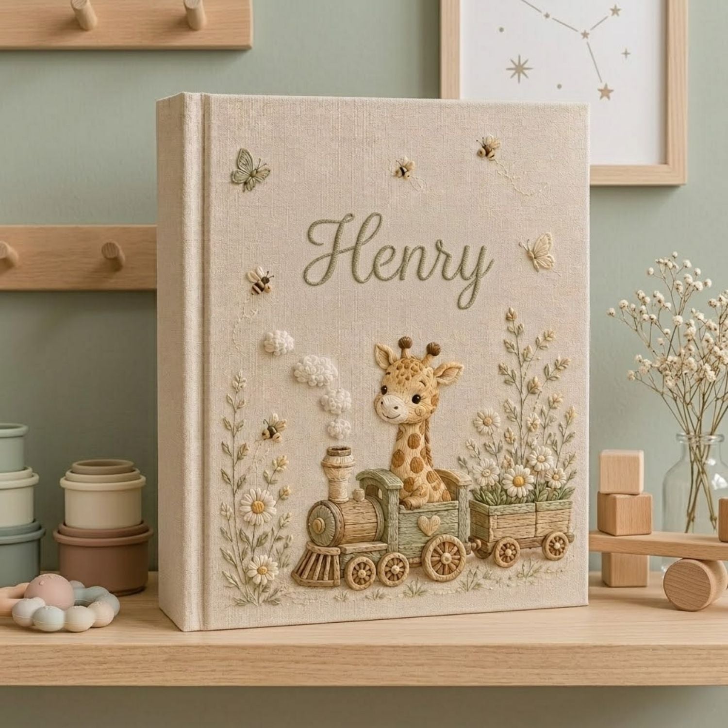 Personalized hand embroidered photo album featuring a baby giraffe riding a vintage train surrounded by daisies, butterflies, and honeybees on a premium linen cover customized with a baby name