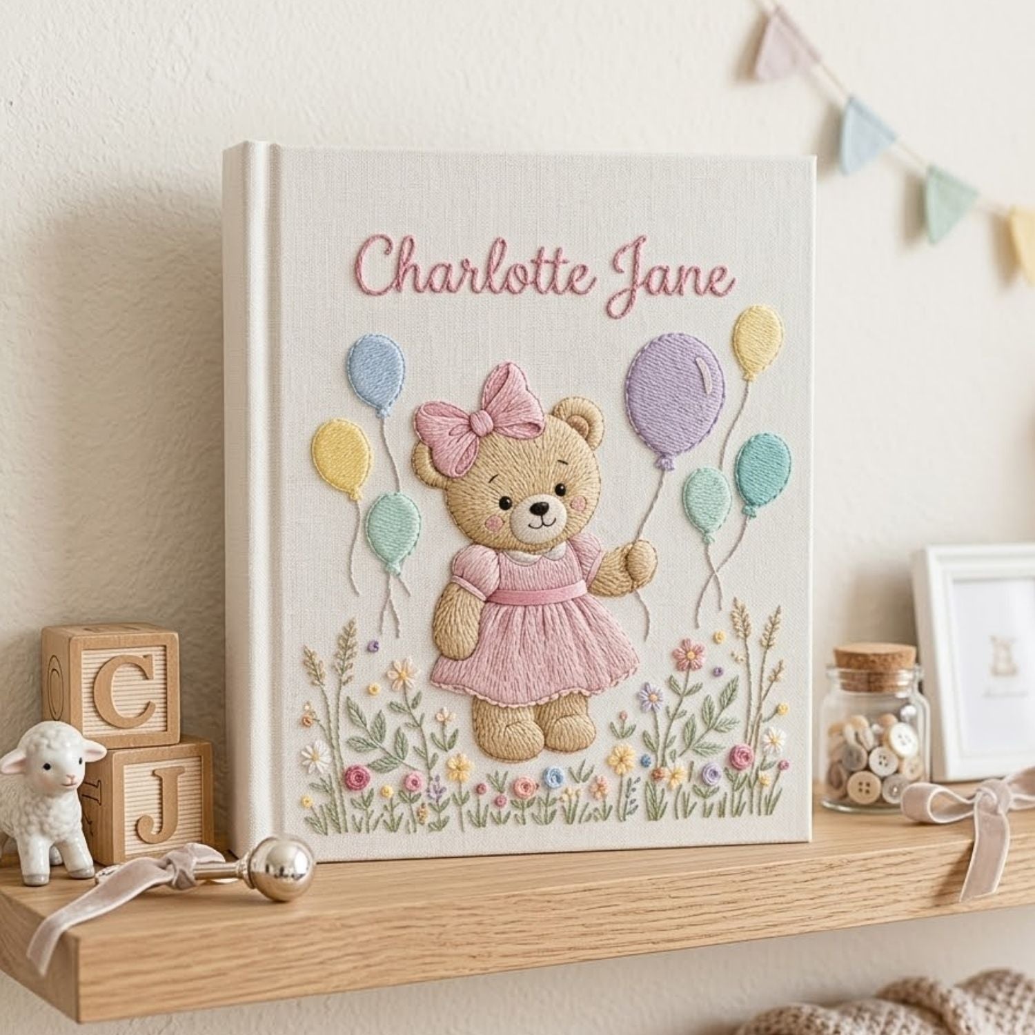 Personalized hand embroidered photo album featuring a birthday teddy bear holding pastel balloons in a blooming flower garden