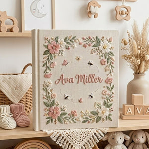 Personalized hand embroidered photo album featuring a floral garden wreath with bees, butterflies, delicate flowers and custom embroidered name on linen cover