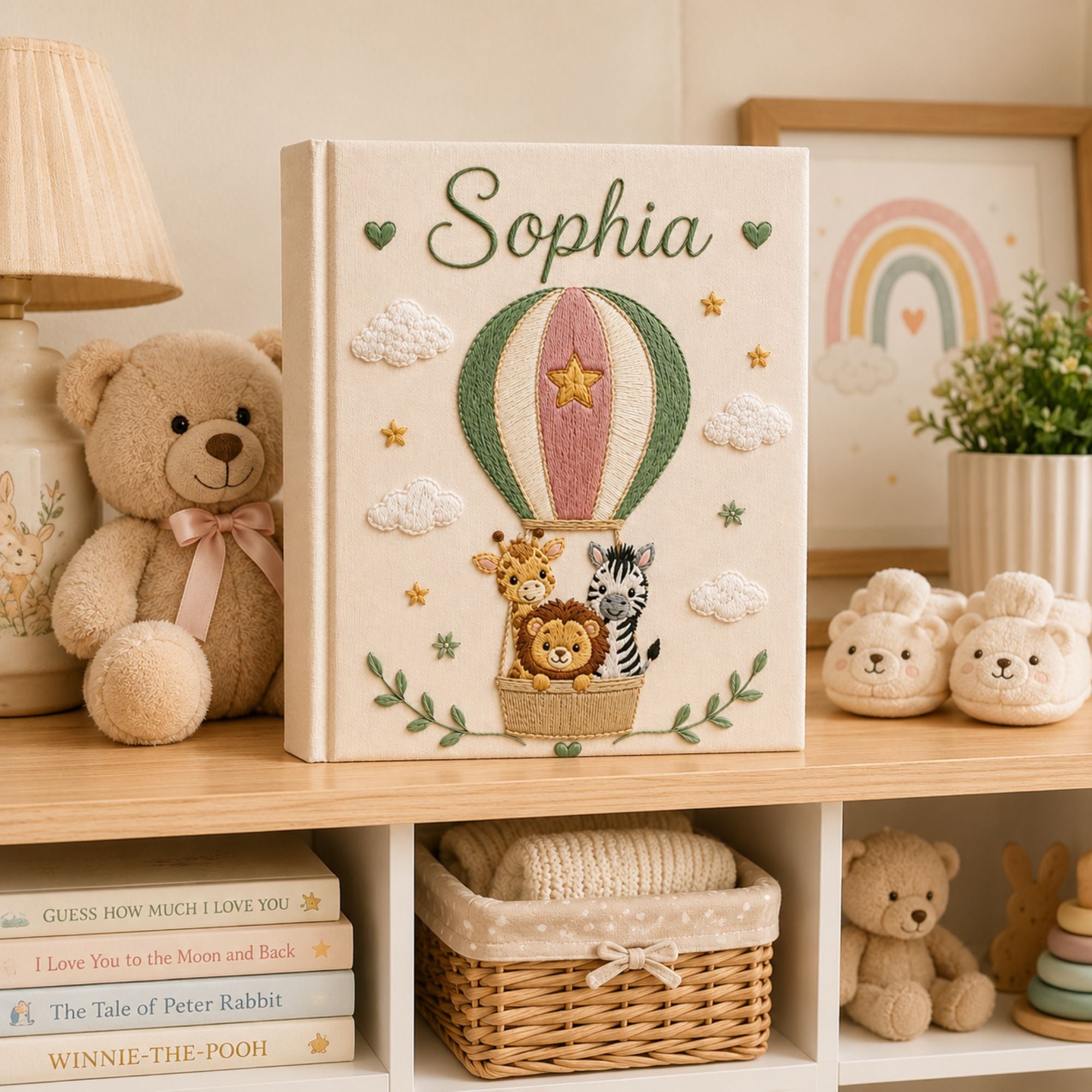 Personalized hand embroidered photo album featuring a lion giraffe and zebra riding in a hot air balloon with clouds stars and custom baby name on a linen cover