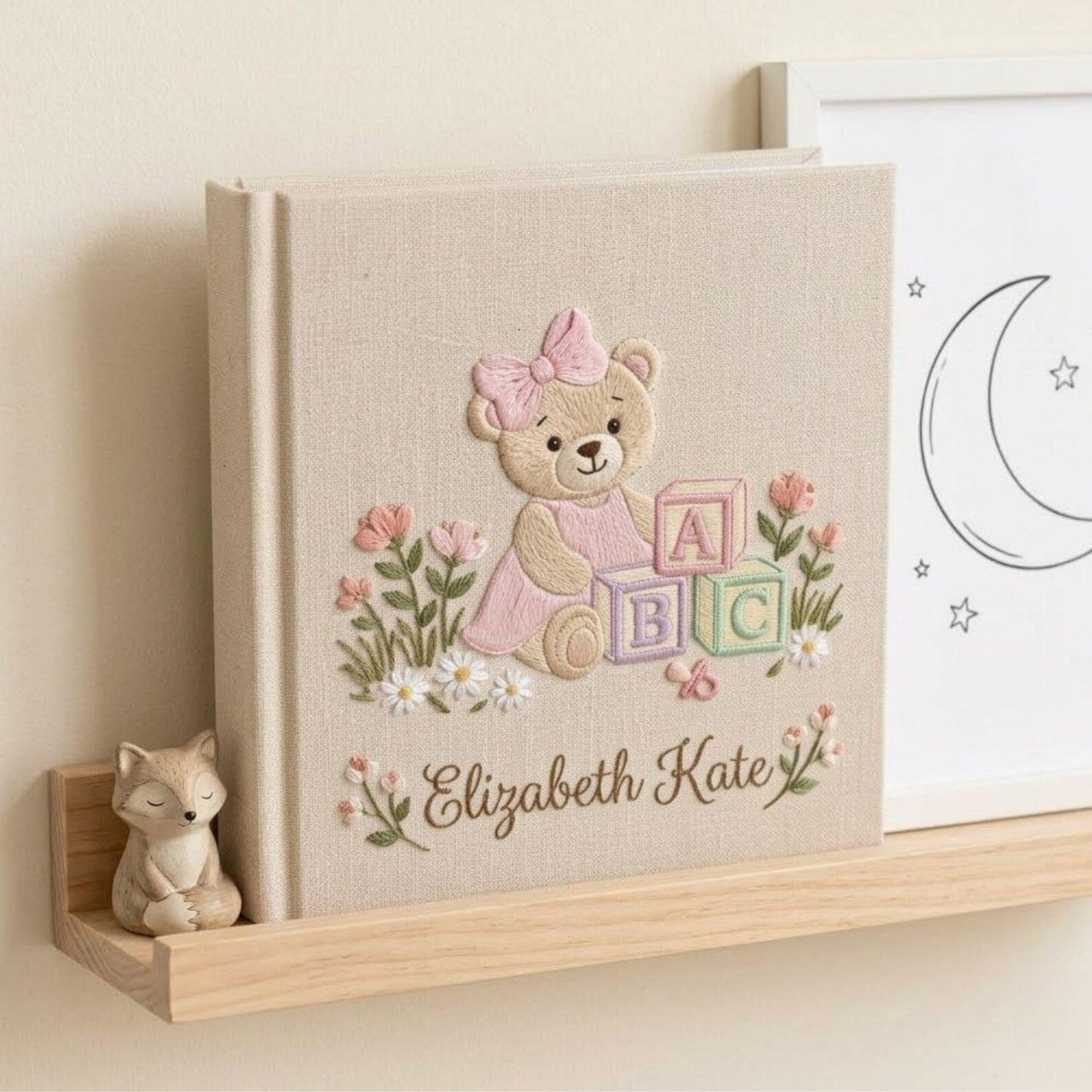 Personalized hand embroidered photo album featuring a teddy bear with pastel ABC blocks floral accents and custom name embroidery