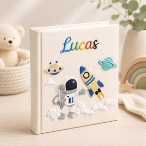 Personalized hand embroidered photo album featuring astronaut rocket ship planets and custom baby name on linen cover