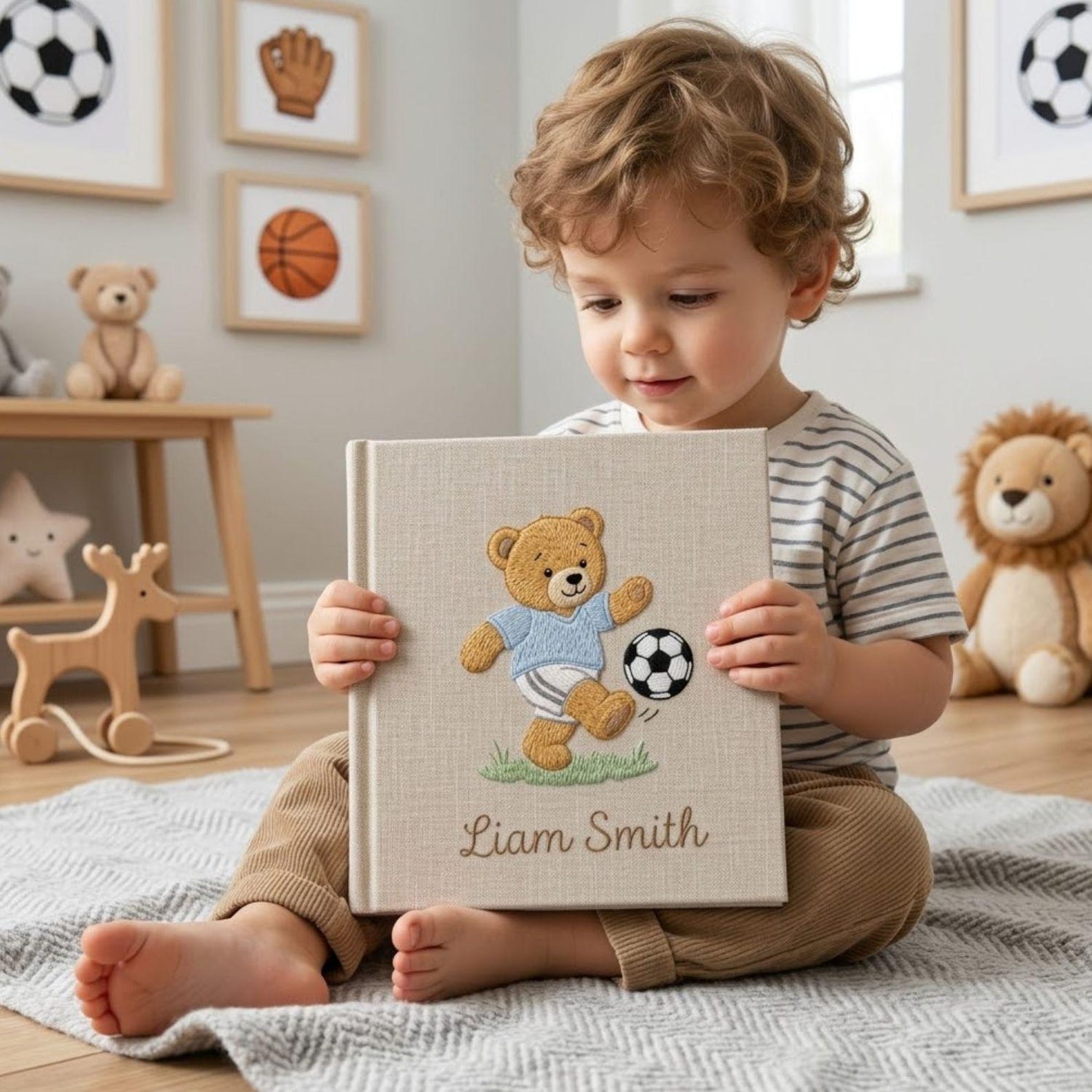 Personalized hand embroidered photo album featuring a teddy bear playing soccer with a football and custom baby name on linen cover