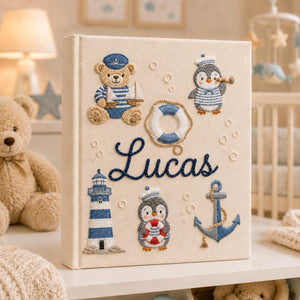 Personalized hand embroidered nautical baby photo album with sailor teddy bear, penguins, lighthouse, and anchor design
