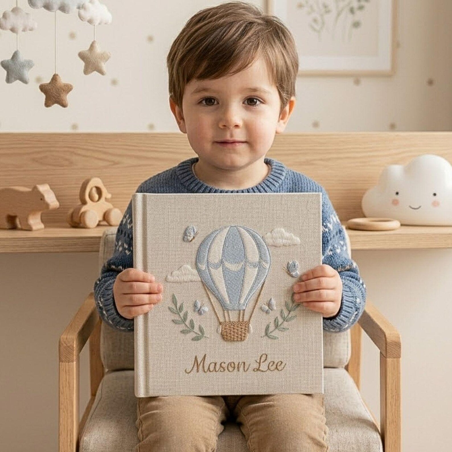 Personalized hand embroidered photo album featuring a blue hot air balloon with butterflies clouds and custom baby name