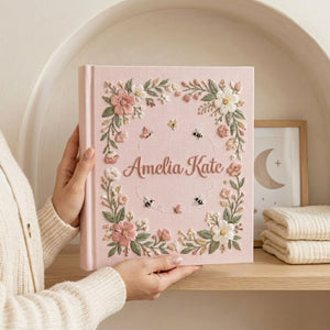 Personalized hand embroidered photo album featuring a floral garden wreath with bees, butterflies, delicate flowers and custom embroidered name on linen cover