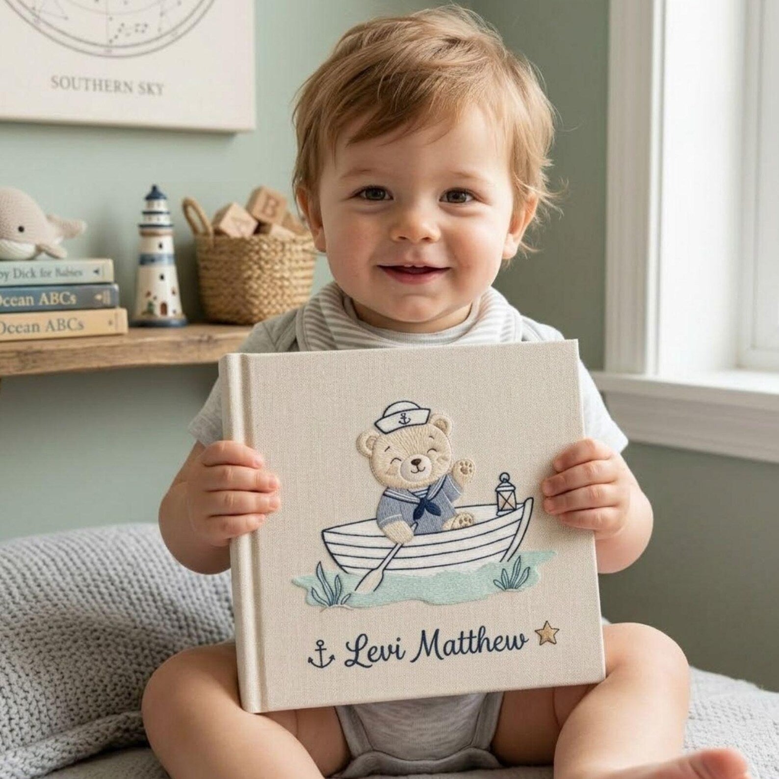 Personalized hand embroidered baby photo album with sailor teddy bear rowing a boat in a nautical nursery theme