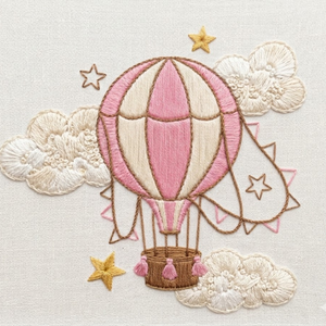 Personalized hand embroidered photo album featuring a vintage hot air balloon floating among clouds and stars on a linen cover