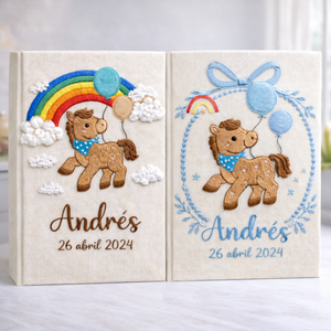 Personalized hand embroidered photo album featuring an adorable pony with balloons, colorful rainbow, fluffy clouds, and custom name embroidery on linen cover