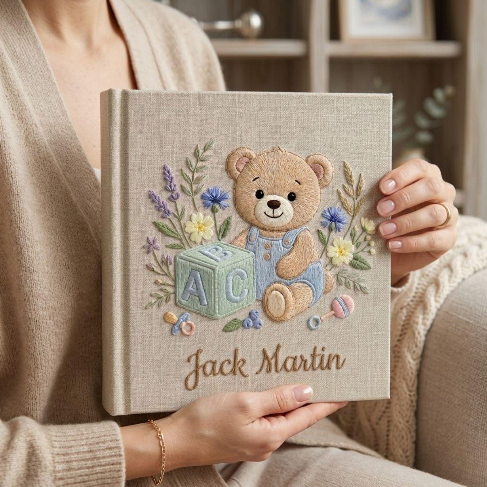 Personalized hand embroidered photo album featuring teddy bear in blue overalls with alphabet block and floral details on linen cover