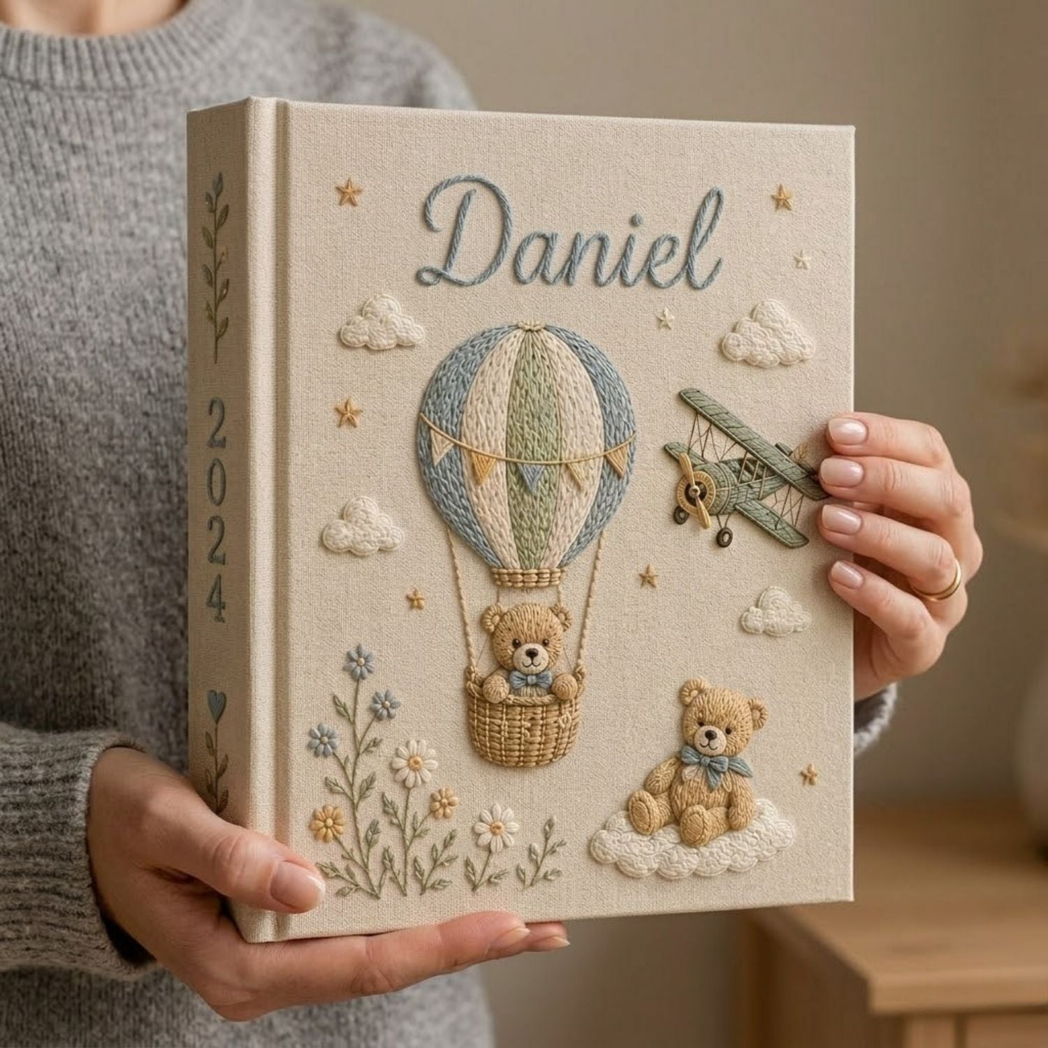 Personalized hand embroidered photo album featuring a teddy bear in a vintage hot air balloon with a classic biplane, clouds, stars, wildflowers, custom name and year embroidery on a premium linen cover
