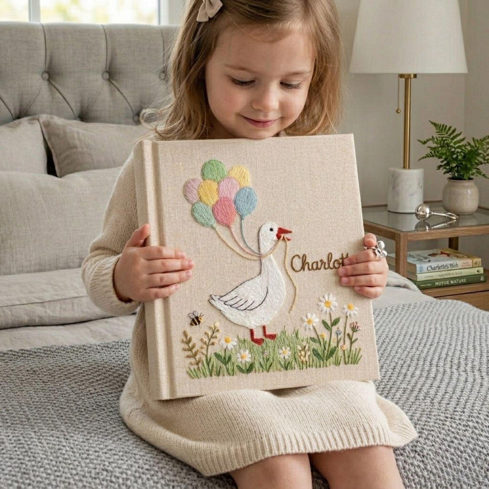 Personalized goose hand embroidered baby photo album with pastel balloons and floral meadow design on linen cover