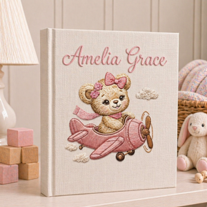 Personalized hand embroidered photo album featuring a vintage aviator teddy bear flying a classic airplane with balloon and banner details