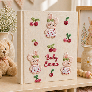 Personalized hand embroidered photo album featuring teddy bears, botanical flowers, leafy accents and custom baby name embroidery on a linen cover