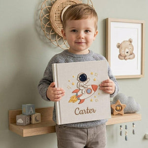 Personalized hand embroidered baby photo album with astronaut riding rocket and stars nursery design