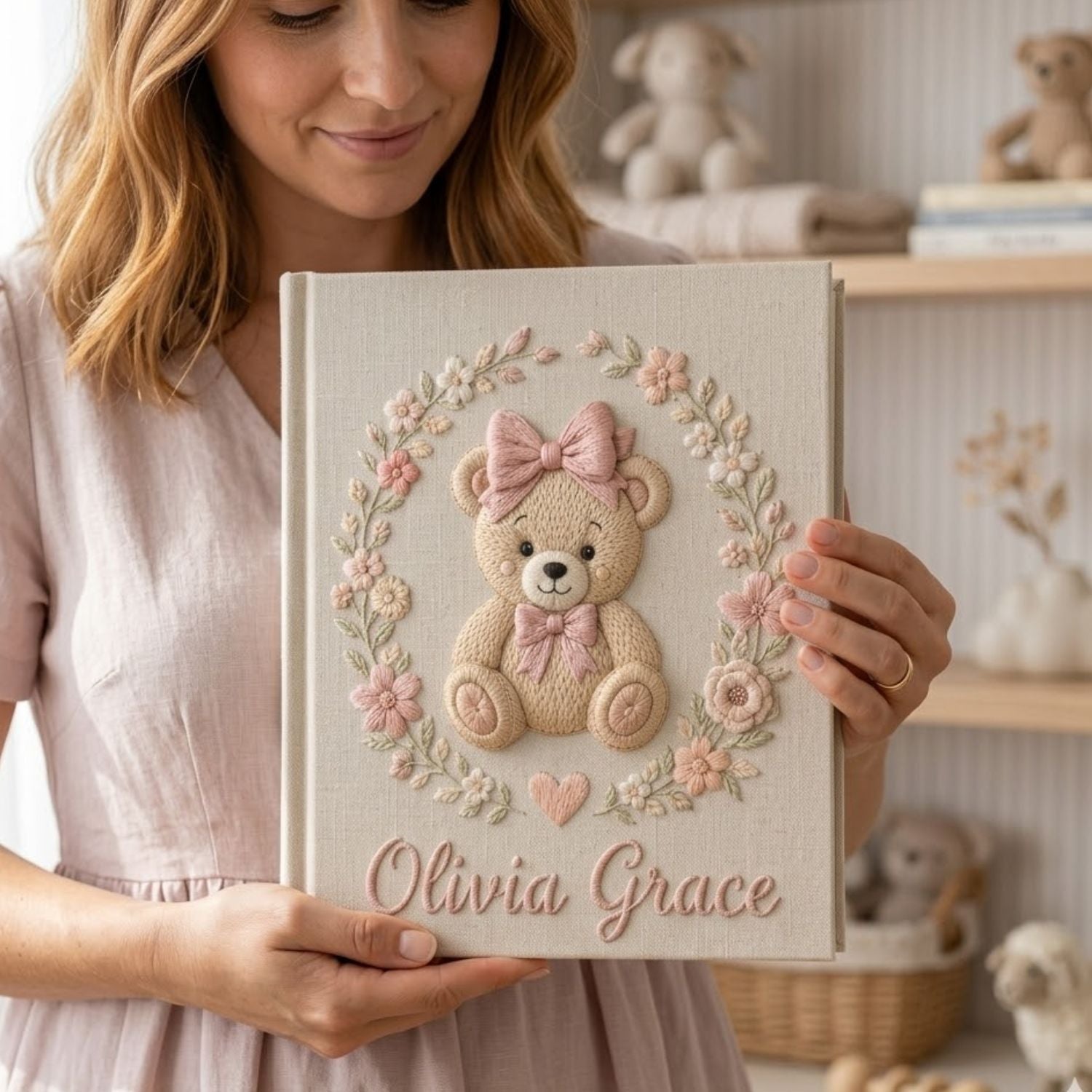 Personalized hand embroidered photo album featuring a classic teddy bear with pink bows and delicate floral embroidery on a linen cover