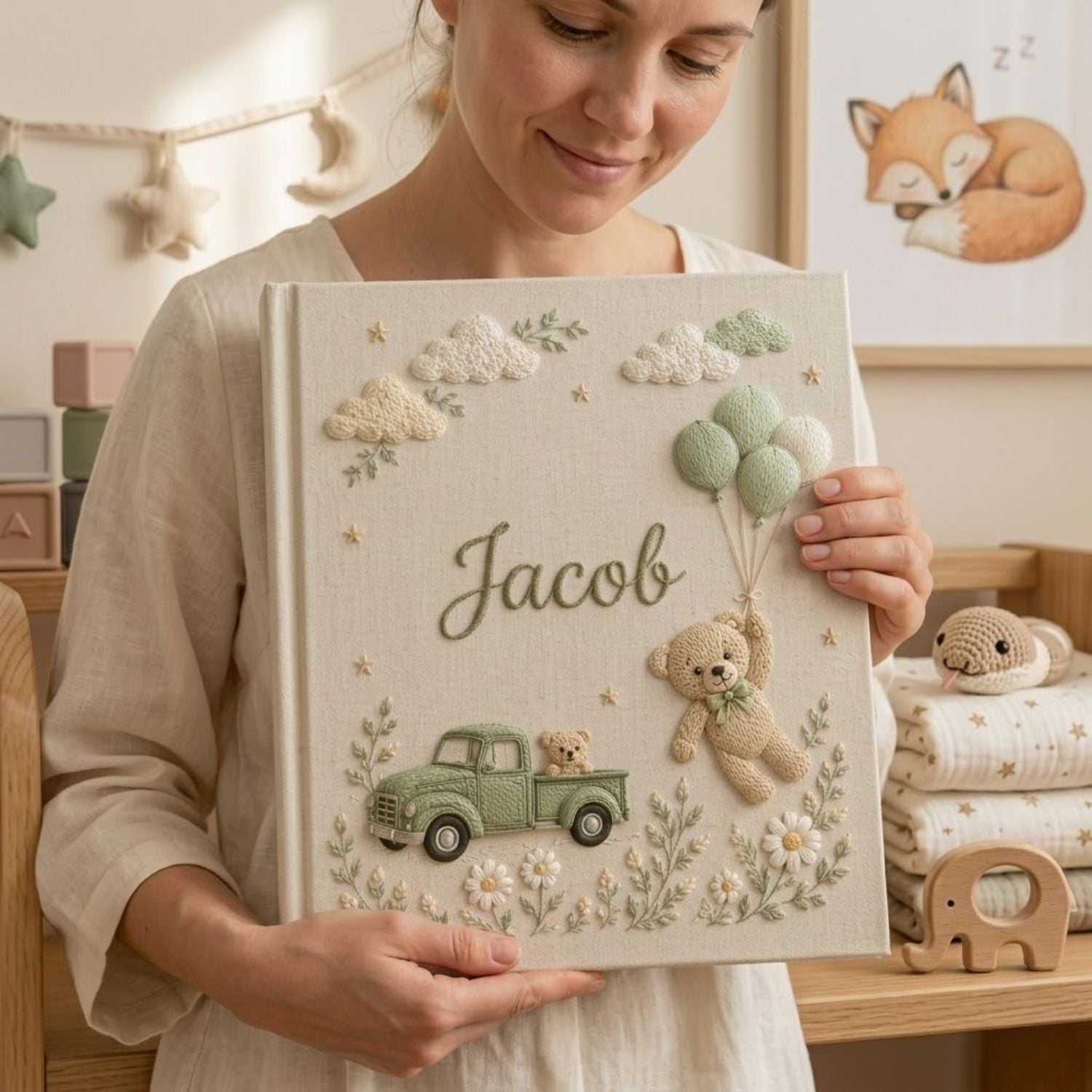 Personalized hand embroidered photo album featuring a vintage sage green pickup truck, floating teddy bear with balloons, clouds, and wildflowers on a premium linen cover customized with a baby name