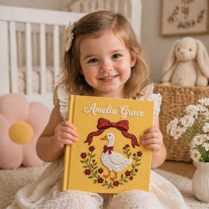 Personalized hand embroidered photo album featuring an elegant goose surrounded by a floral berry wreath on a golden linen cover
