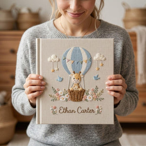 Personalized hand embroidered photo album featuring a baby giraffe in a hot air balloon with flowers clouds birds and custom name embroidery