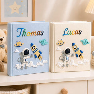Personalized hand embroidered photo album featuring astronaut rocket ship planets and custom baby name on linen cover