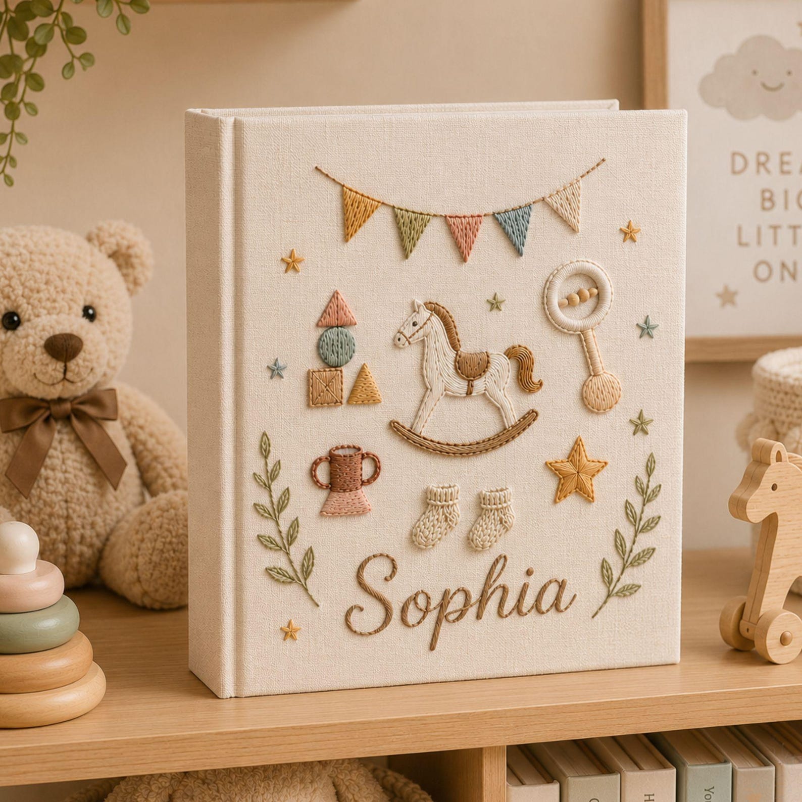 Personalized hand embroidered baby photo album with rocking horse, baby rattle, bunting flags, and vintage nursery toys