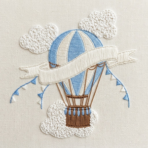 Personalized hand embroidered photo album featuring a vintage hot air balloon floating among clouds and stars on a linen cover