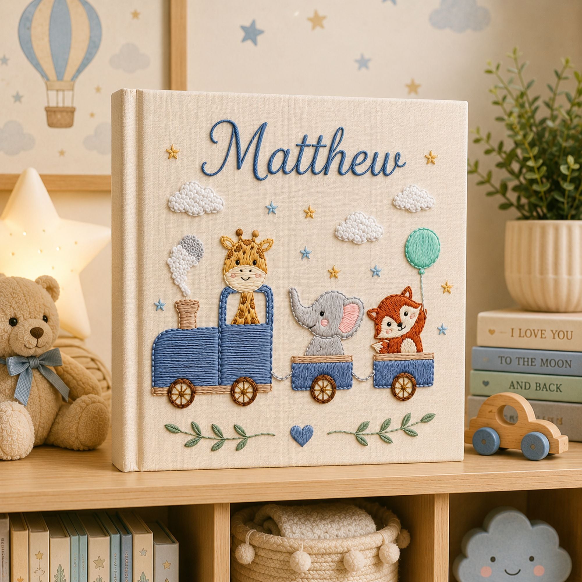 Personalized hand embroidered photo album featuring a safari animal train with giraffe, hippo, lion and zebra on a linen cover