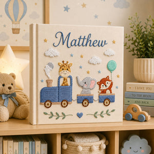 Personalized hand embroidered photo album featuring a safari animal train with giraffe, hippo, lion and zebra on a linen cover