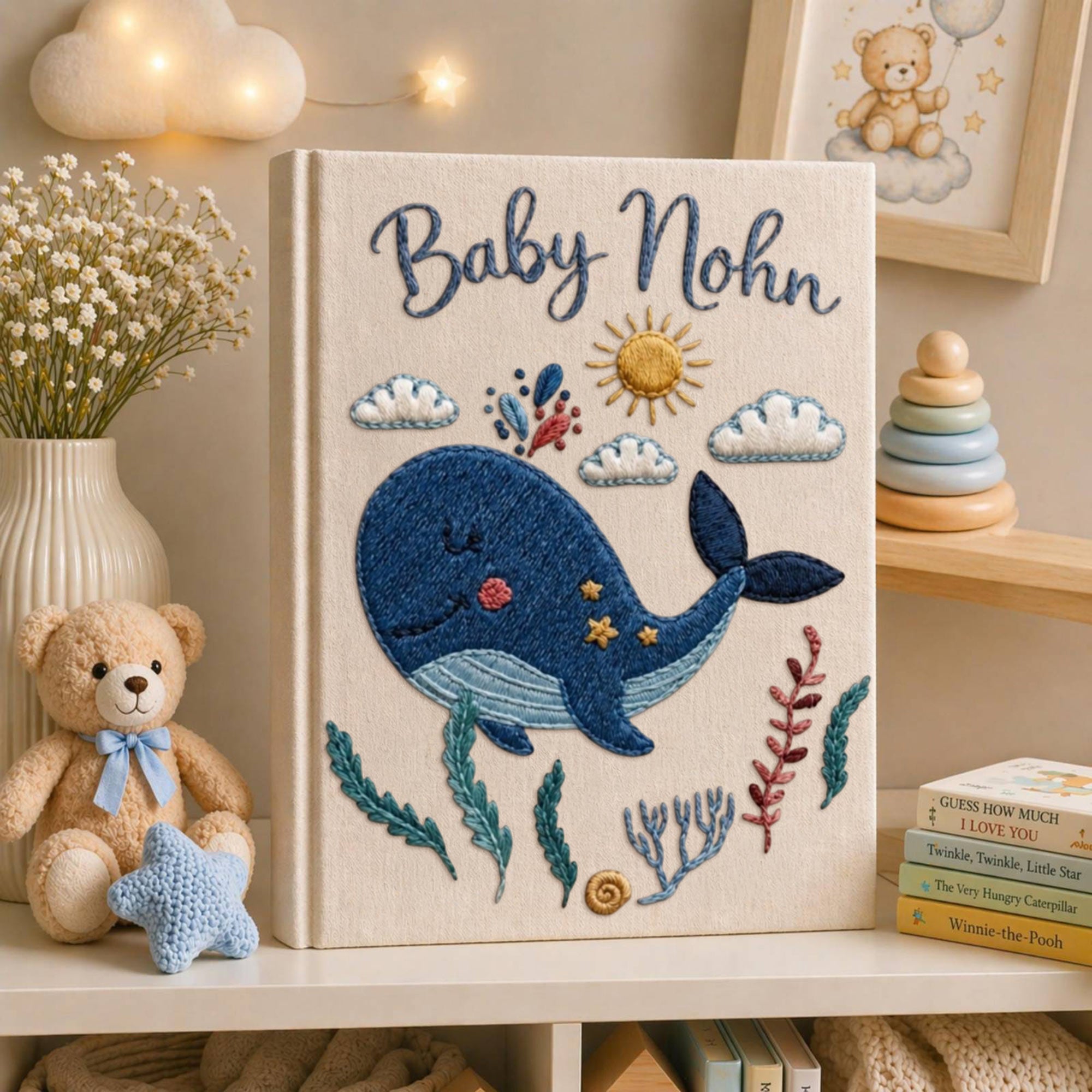 Personalized embroidered baby photo album with smiling whale, ocean plants, clouds, sunshine, and custom name embroidery