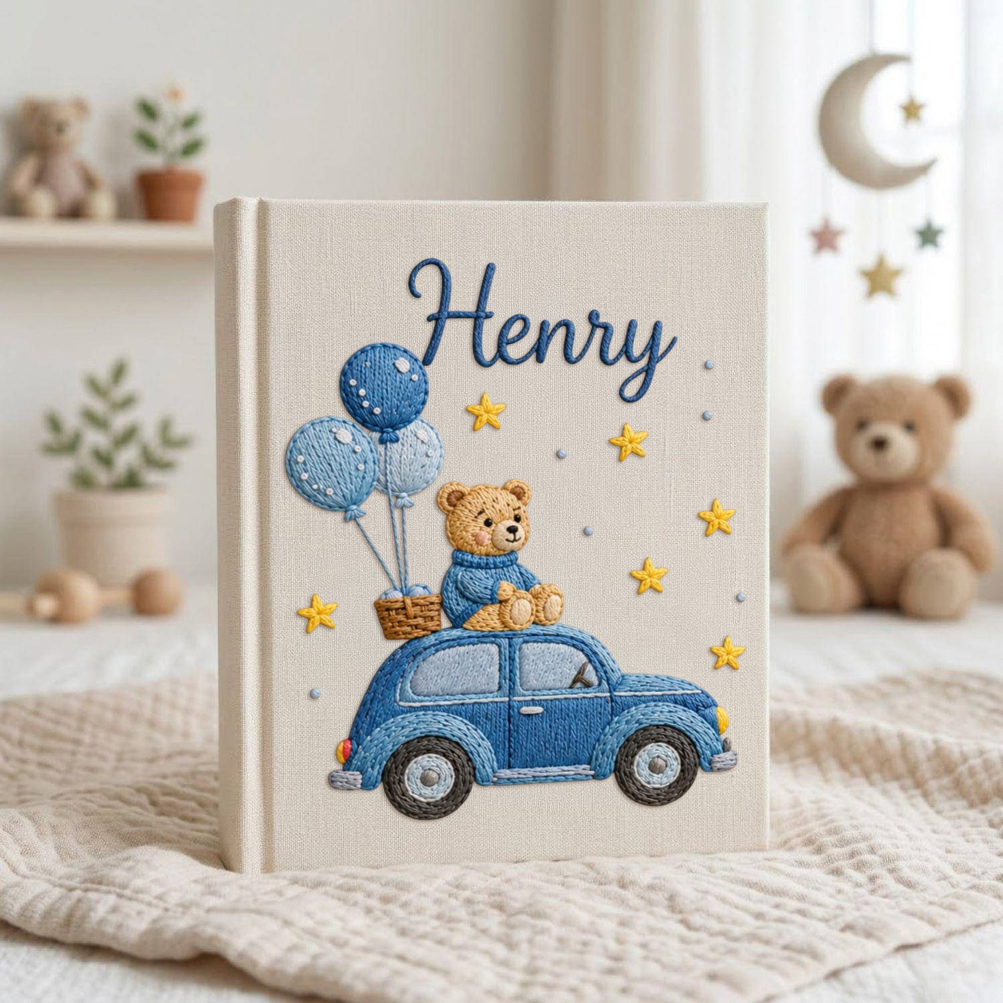 Personalized hand embroidered baby photo album featuring teddy bear riding a blue vintage car with balloons and stars on linen cover