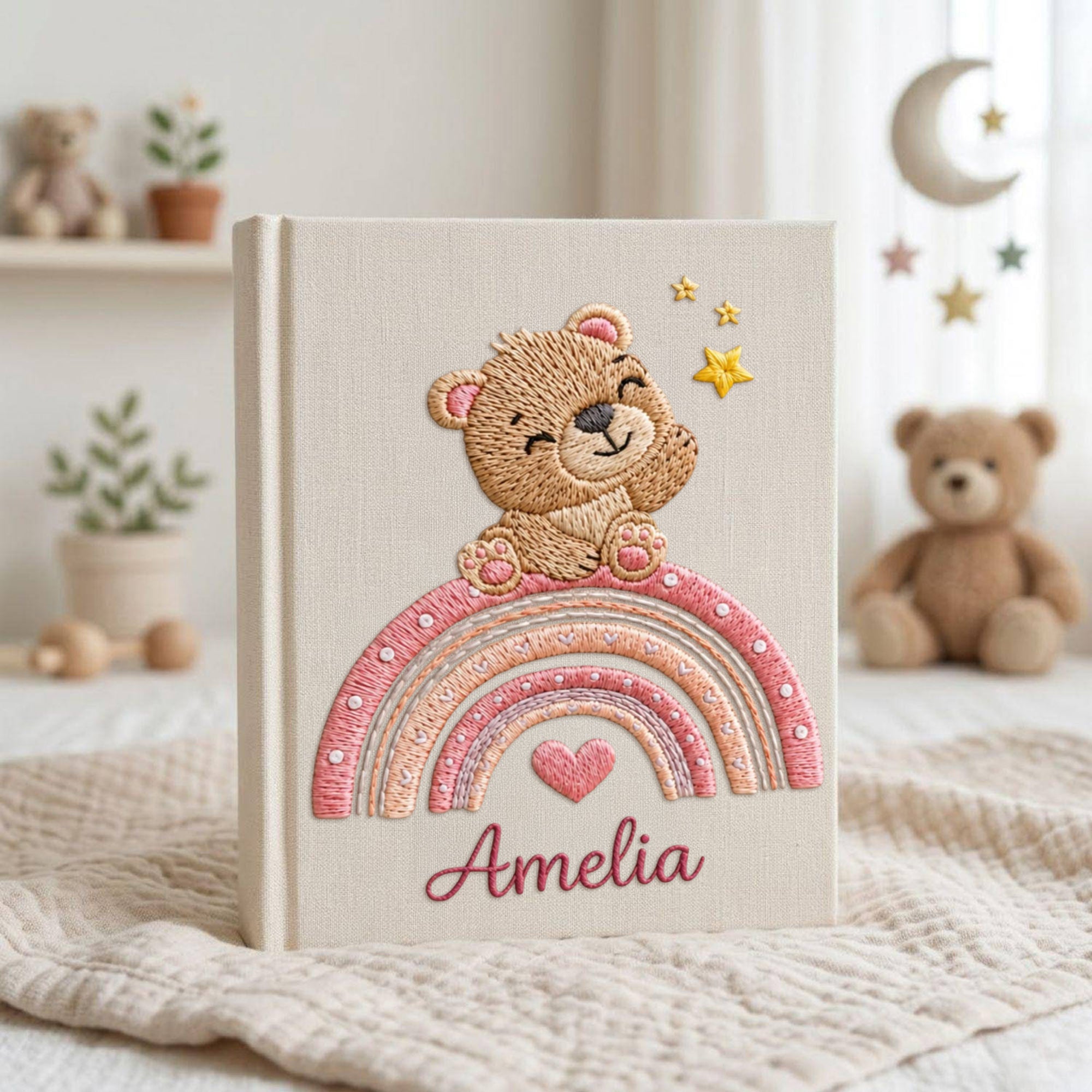 Personalized hand embroidered baby photo album featuring teddy bear sitting on pastel rainbow with stars and heart accents
