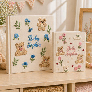 Personalized hand embroidered photo album featuring teddy bears, botanical flowers, leafy accents and custom baby name embroidery on a linen cover