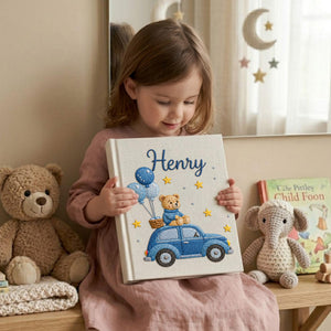 Personalized hand embroidered baby photo album featuring teddy bear riding a blue vintage car with balloons and stars on linen cover