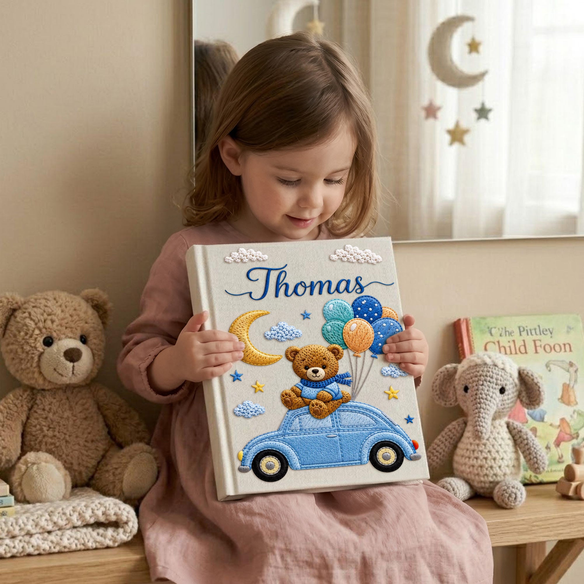 Personalized hand embroidered baby photo album featuring teddy bear on vintage blue car with balloons, moon, stars, and custom name embroidery