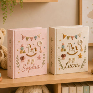Personalized hand embroidered baby photo album with rocking horse, baby rattle, bunting flags, and vintage nursery toys